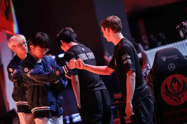 T1 fist bump G2 Esports on stage during MSI Bracket Stage.