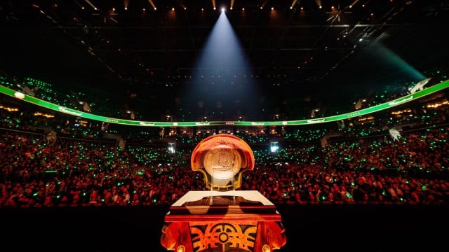 L'Aegis des Champions repose sur un socle avec une foule qui l'observe depuis les tribunes.