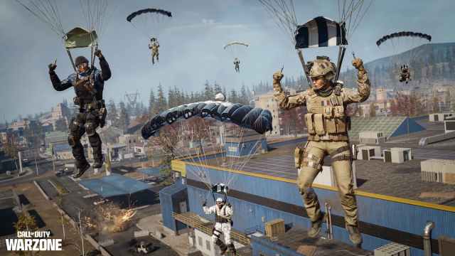 De nombreux soldats parachutant au-dessus d'une rangée de maisons et de bâtiments dans COD Warzone.